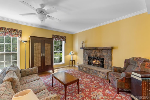 living room featuring ceiling fan, ornamental molding, a healthy amount of sunlight, and a fireplace