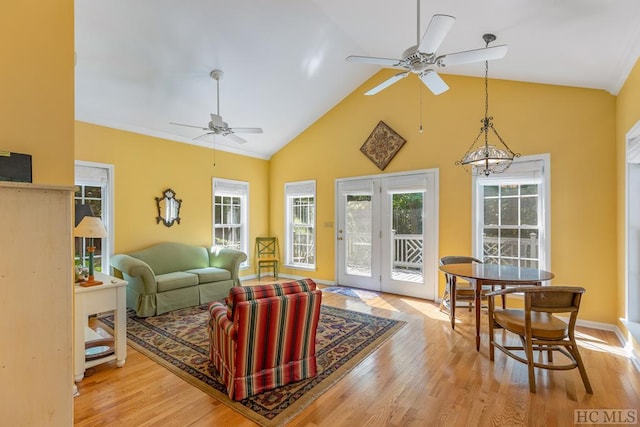 living room with ceiling fan, high vaulted ceiling, and light wood-type flooring