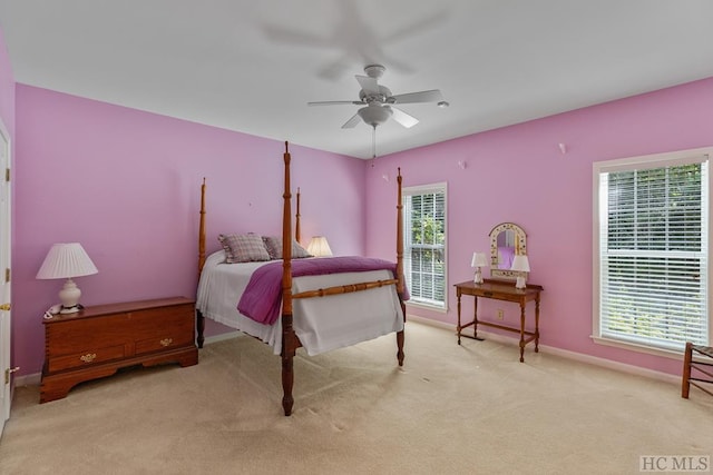 carpeted bedroom with multiple windows and ceiling fan