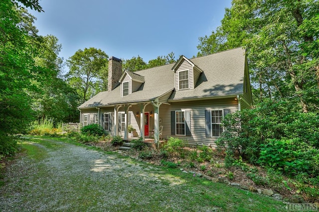 cape cod home with a front lawn