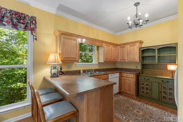 kitchen with pendant lighting, kitchen peninsula, sink, light hardwood / wood-style floors, and white dishwasher