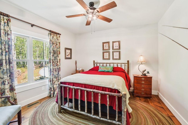 bedroom with baseboards, wood finished floors, and ceiling fan