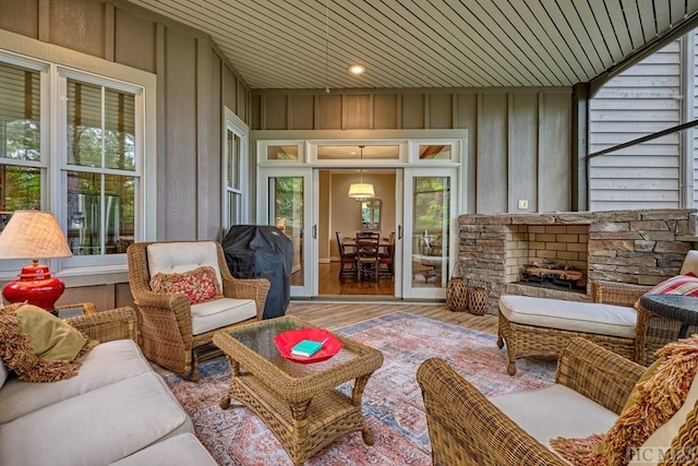 sunroom / solarium with wood ceiling and a fireplace