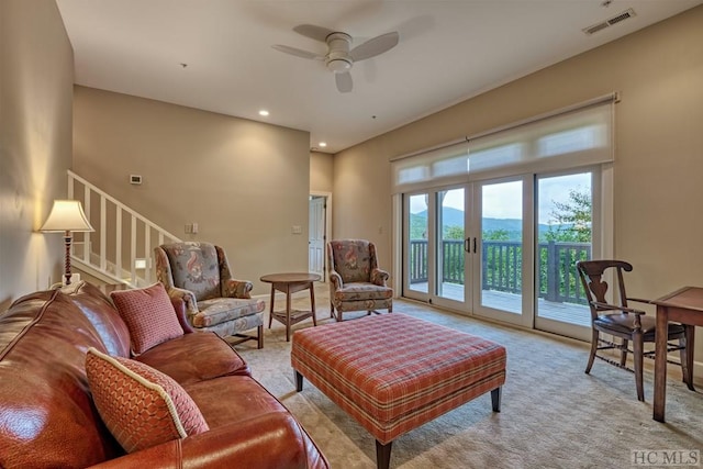 carpeted living room with ceiling fan and french doors