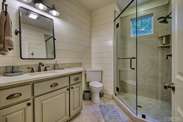 bathroom with vanity, wooden walls, an enclosed shower, and tile patterned floors