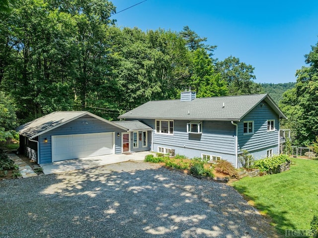 view of front of property featuring a garage, an outdoor structure, and a front yard