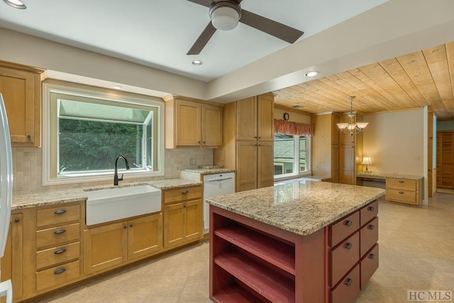 kitchen featuring decorative backsplash, dishwasher, a center island, hanging light fixtures, and a sink