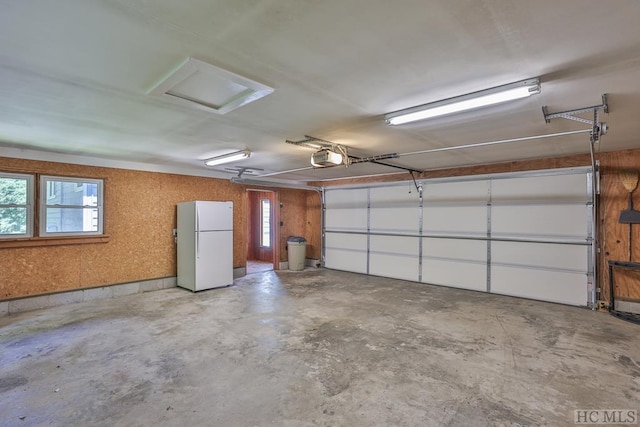 garage featuring a garage door opener and freestanding refrigerator