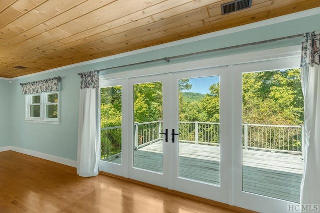 doorway to outside with wooden ceiling, baseboards, visible vents, and wood finished floors