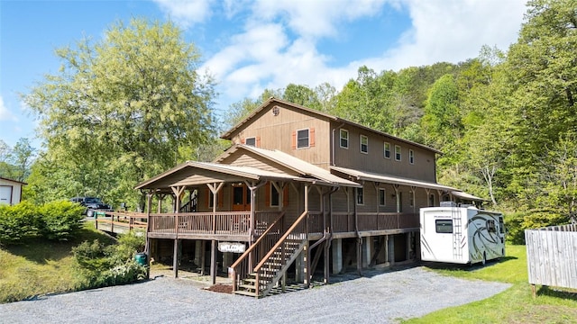 back of property featuring covered porch and stairway