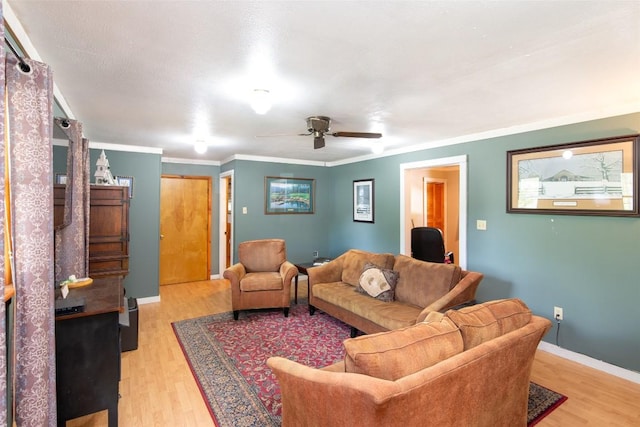 living area with light wood-type flooring, a ceiling fan, baseboards, and crown molding