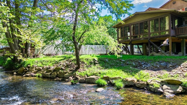 view of yard with fence and a sunroom