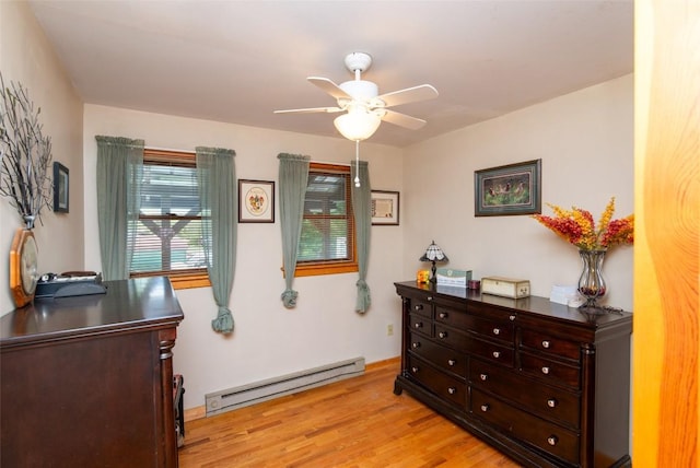 bedroom featuring a baseboard radiator, light wood finished floors, ceiling fan, and an office area