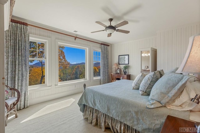 carpeted bedroom featuring crown molding and ceiling fan