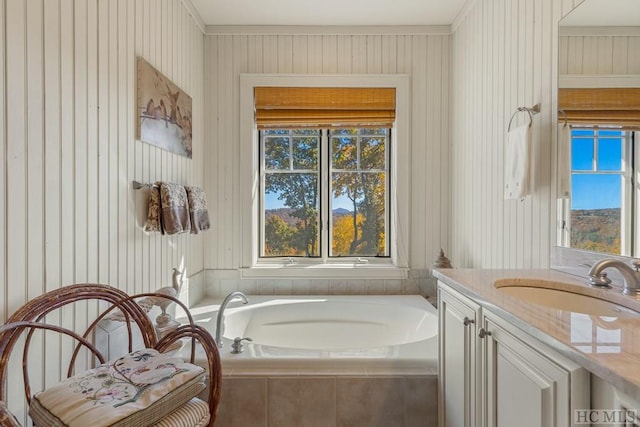 bathroom with vanity and tiled bath