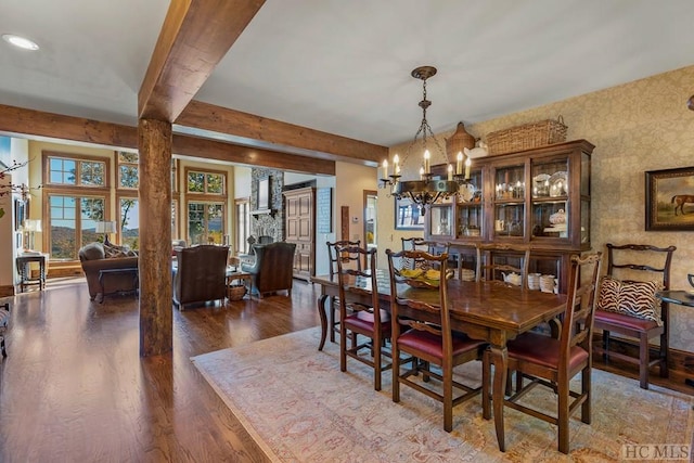 dining area with dark hardwood / wood-style flooring, a notable chandelier, and beam ceiling