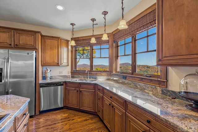 kitchen featuring pendant lighting, sink, dark stone counters, and appliances with stainless steel finishes