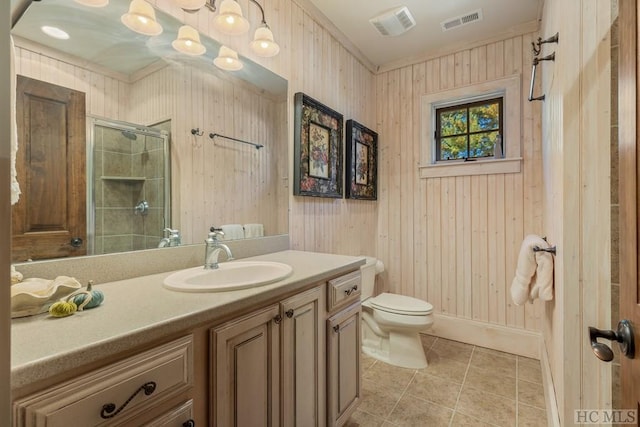 bathroom with tile patterned floors, toilet, a shower with shower door, wood walls, and vanity