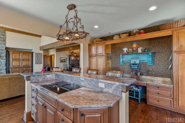 kitchen featuring a kitchen island, pendant lighting, dark hardwood / wood-style flooring, a kitchen breakfast bar, and black electric stovetop