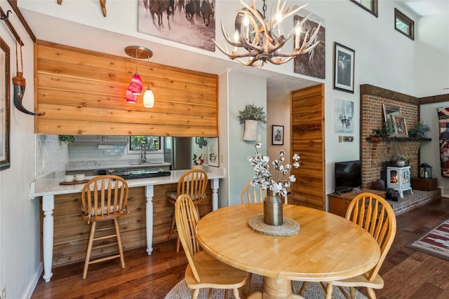 38 Lonely Mountain Dr Unit 24-A, Sapphire, NC 28774 - dining room with wood finished floors, a wood stove, a chandelier, and a towering ceiling