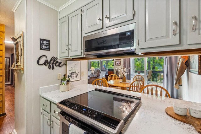 38 Lonely Mountain Dr Unit 24-A, Sapphire, NC 28774 - kitchen with electric range, stainless steel microwave, ornamental molding, light stone countertops, and wood finished floors