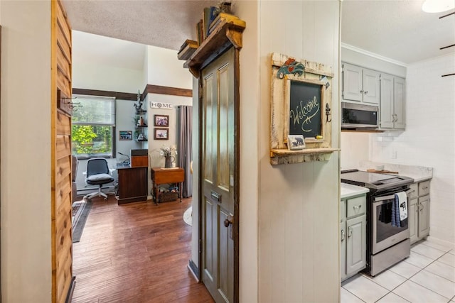 38 Lonely Mountain Dr Unit 24-A, Sapphire, NC 28774 - kitchen featuring appliances with stainless steel finishes, gray cabinetry, light wood finished floors, light countertops, and crown molding