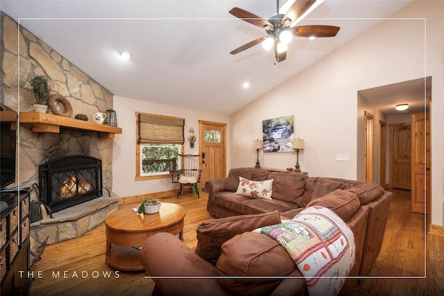 living room featuring a fireplace, a ceiling fan, and wood finished floors