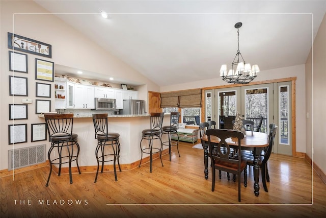 dining room featuring a chandelier, visible vents, and light wood-style flooring