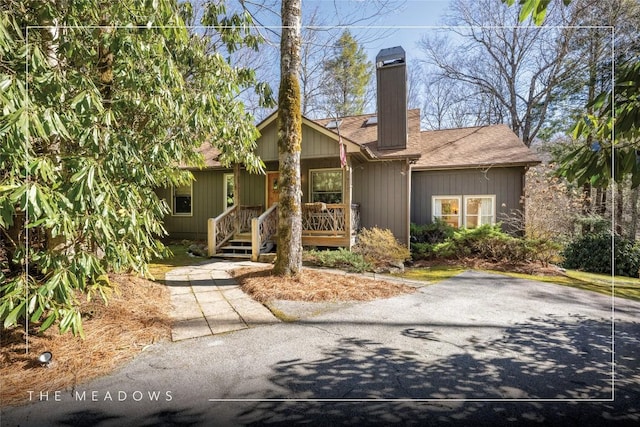 view of front of property featuring roof with shingles and a chimney