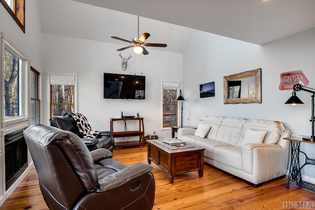 living room featuring hardwood / wood-style floors, high vaulted ceiling, and ceiling fan