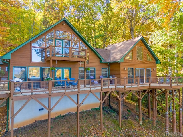 back of property with a deck and a balcony