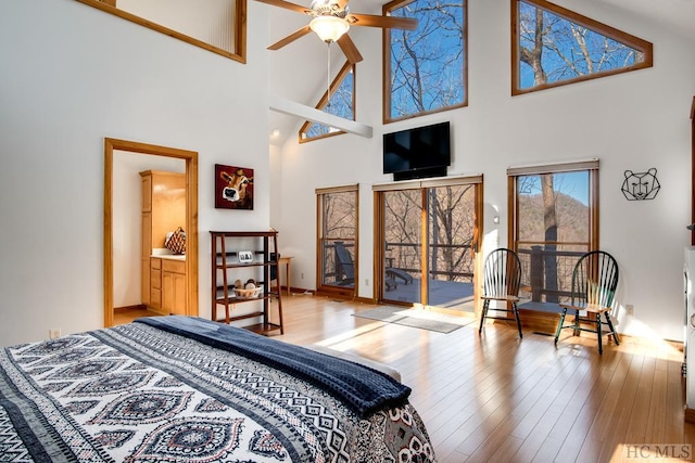 bedroom with light wood-type flooring, access to exterior, and a high ceiling