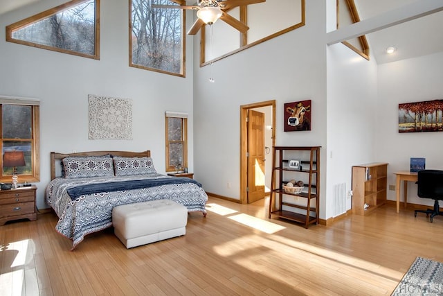 bedroom featuring hardwood / wood-style floors and a high ceiling