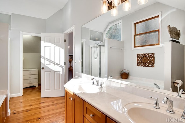 bathroom featuring lofted ceiling, vanity, a shower with shower door, and hardwood / wood-style floors