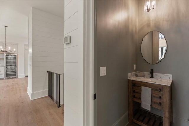 2608 Magnolia Dr, Highlands, NC 28741 - bathroom with wine cooler, a chandelier, wood finished floors, and vanity