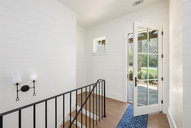 doorway to outside with visible vents, baseboards, and wood finished floors