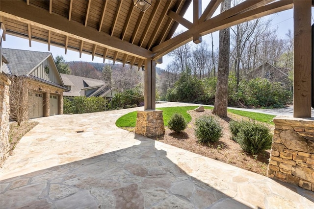 view of patio featuring a garage and driveway