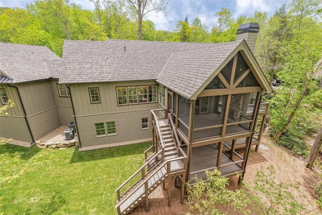 2608 Magnolia Dr, Highlands, NC 28741 - rear view of house with a sunroom, a chimney, stairs, a lawn, and roof with shingles