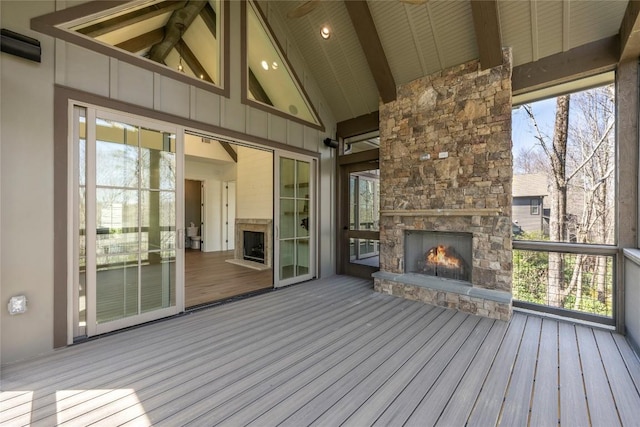 wooden deck with an outdoor stone fireplace