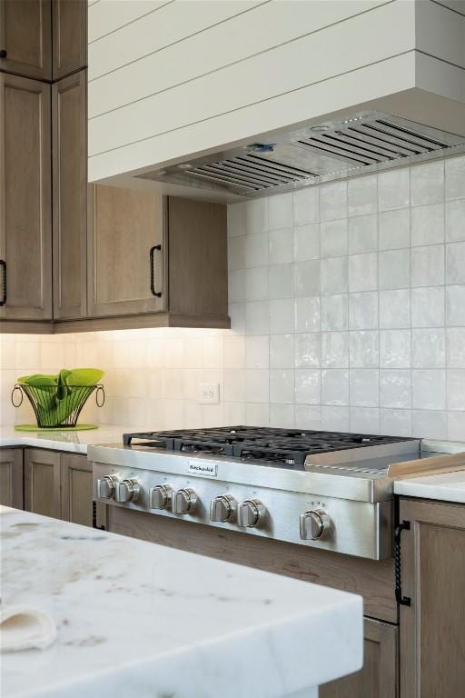 kitchen featuring decorative backsplash, stainless steel gas cooktop, and wall chimney exhaust hood