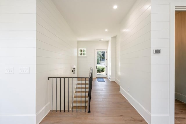 hallway featuring baseboards, recessed lighting, and wood finished floors