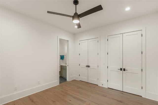 2608 Magnolia Dr, Highlands, NC 28741 - unfurnished bedroom with two closets, wood finished floors, connected bathroom, recessed lighting, and a ceiling fan