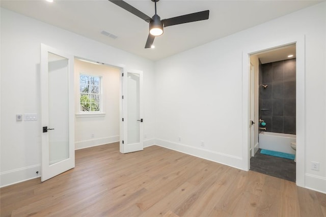 unfurnished bedroom with light wood-style flooring, baseboards, visible vents, and connected bathroom