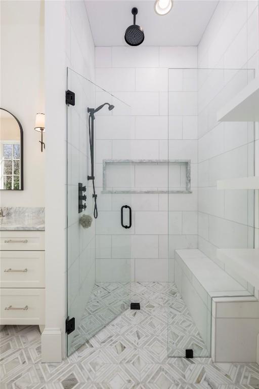 full bath with a stall shower and vanity