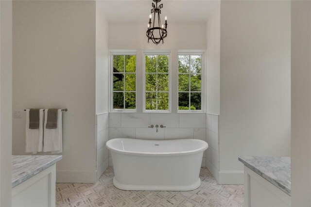 2608 Magnolia Dr, Highlands, NC 28741 - bathroom with vanity, a freestanding bath, a chandelier, and tile walls