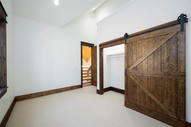 1086 Roaming Rd, Glenville, NC 28736 - unfurnished bedroom featuring baseboards, a barn door, and carpet