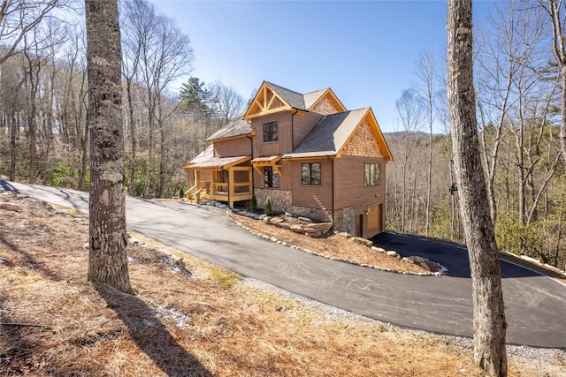 1086 Roaming Rd, Glenville, NC 28736 - view of front of house featuring a forest view, driveway, a shingled roof, and an attached garage