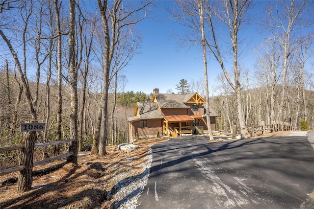 1086 Roaming Rd, Glenville, NC 28736 - view of front of home featuring aphalt driveway, a chimney, a view of trees, and a balcony