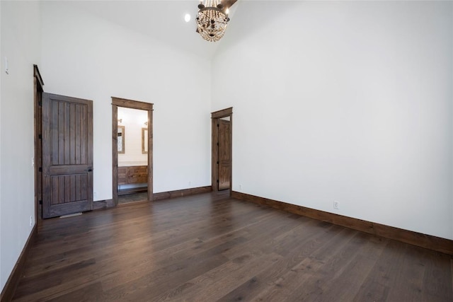 1086 Roaming Rd, Glenville, NC 28736 - spare room with dark wood-type flooring, baseboards, and an inviting chandelier