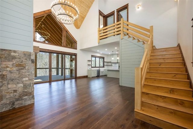 1086 Roaming Rd, Glenville, NC 28736 - unfurnished living room featuring wood finished floors, stairway, and an inviting chandelier
